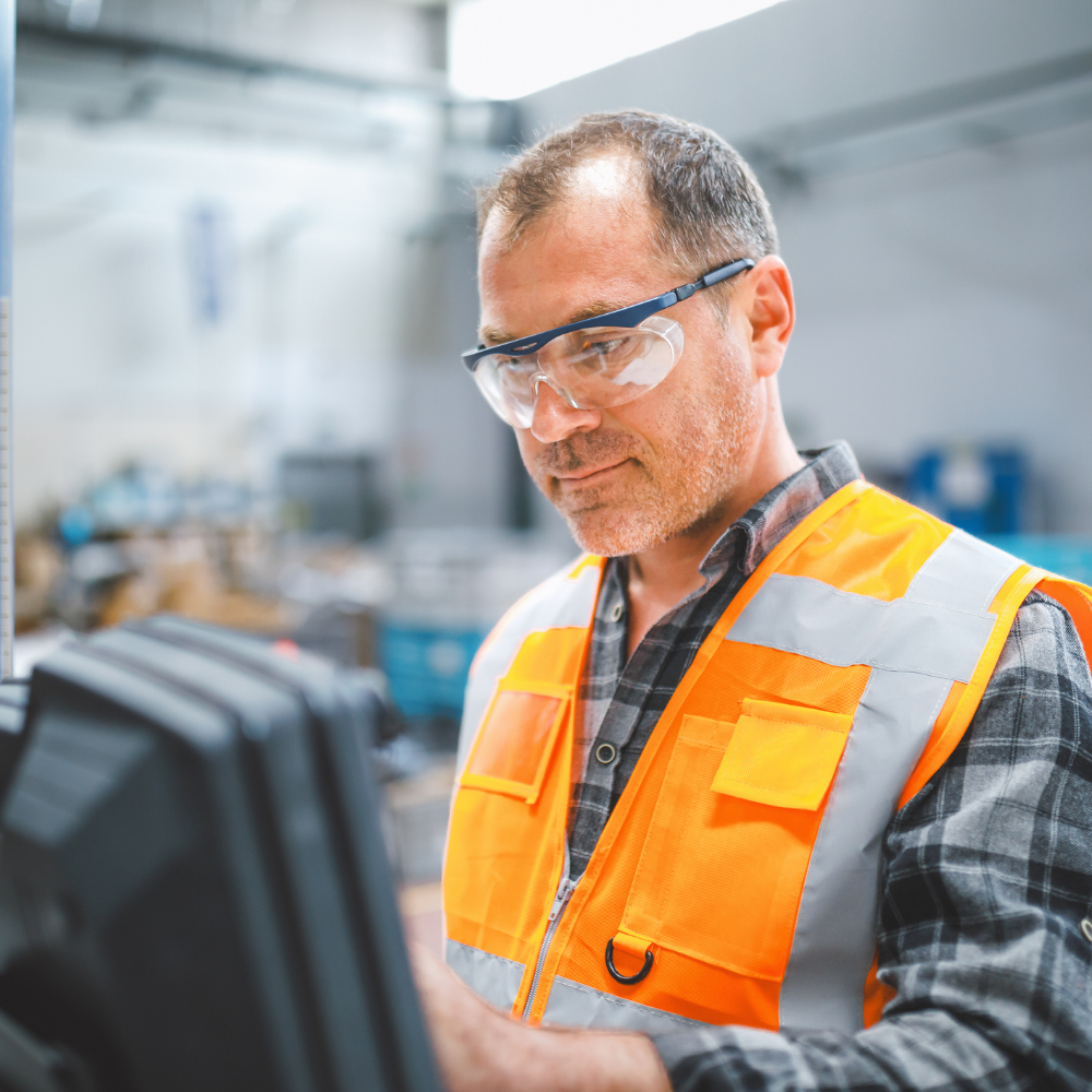 man working in manufacturing plant touching electronic screen