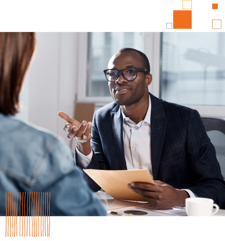 man in office talking to someone across the room