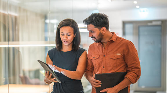 two employees discussing information on tablet