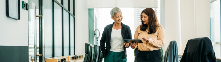two employees using a tablet in a collaborative work environment