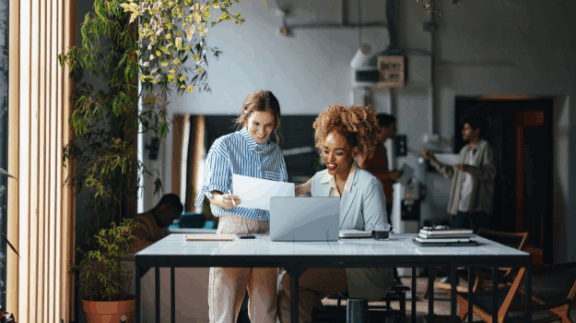 two employees looking at people analytics data on their computers.
