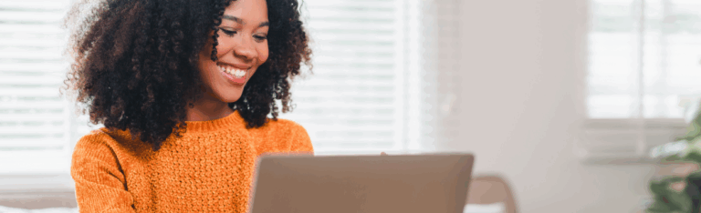 female employee smiling and looking at computer screen