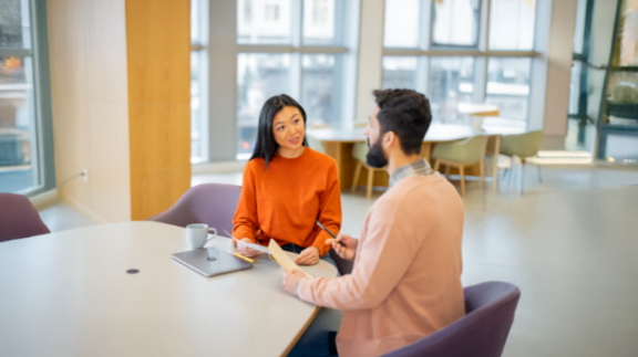 two employees discussing talent management software companies