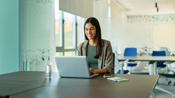female business owner researching for the best workforce management software companies on her laptop