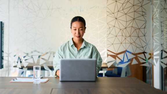 a woman completing employee compliance training on a laptop computer