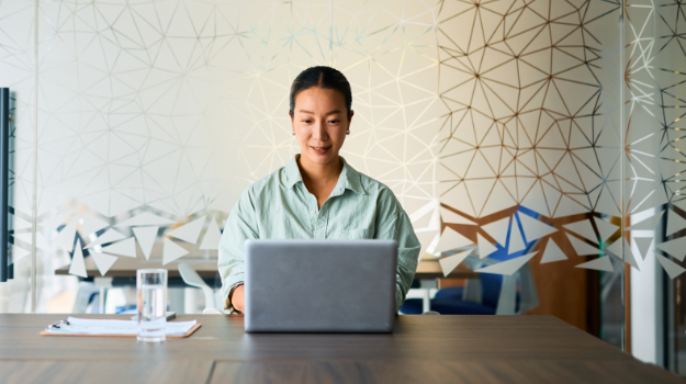 a woman completing employee compliance training on a laptop computer